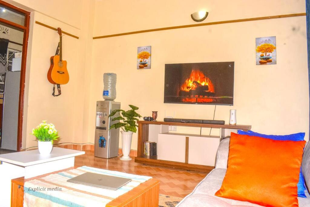 een woonkamer met een bank en een open haard bij The Bay House in Homa Bay