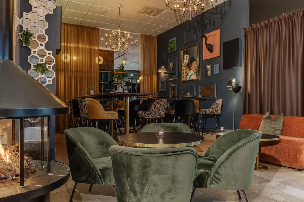 a restaurant with tables and chairs and a fireplace at Best Western Plus Grand Hotel Elektra in Ludvika