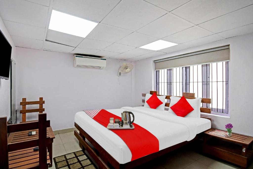 a bedroom with a large bed with red and white pillows at OYO Flagship Dreamy Sunrise By Stayapart Near City Centre Salt Lake in Kolkata