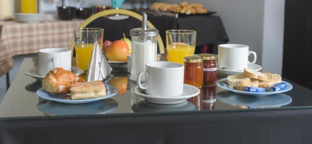 a table topped with plates of breakfast foods and drinks at Hotel San Francisco in San Juan