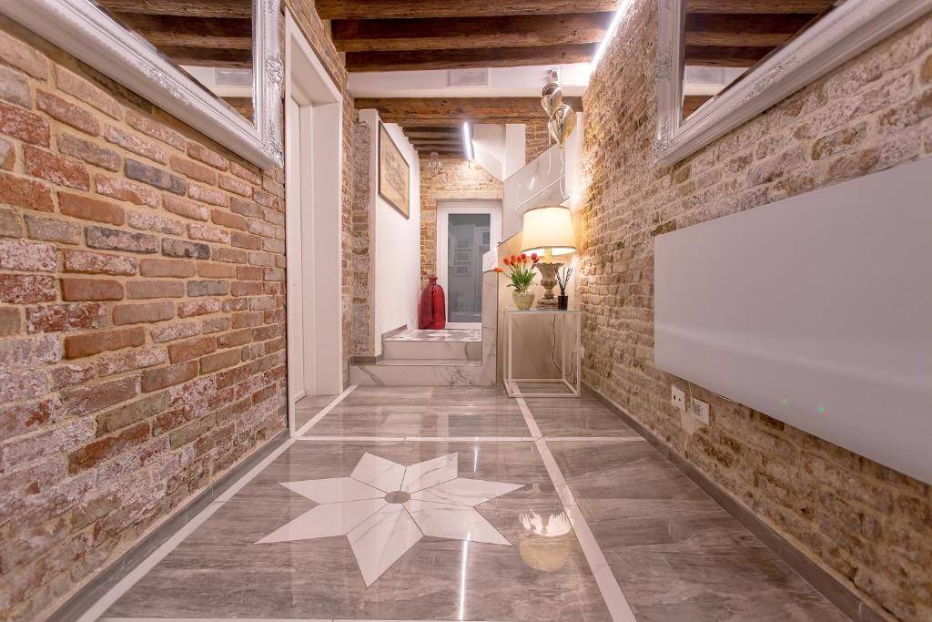 un corridoio con un muro di mattoni e un cartello sul pavimento di CàPatron a Venezia