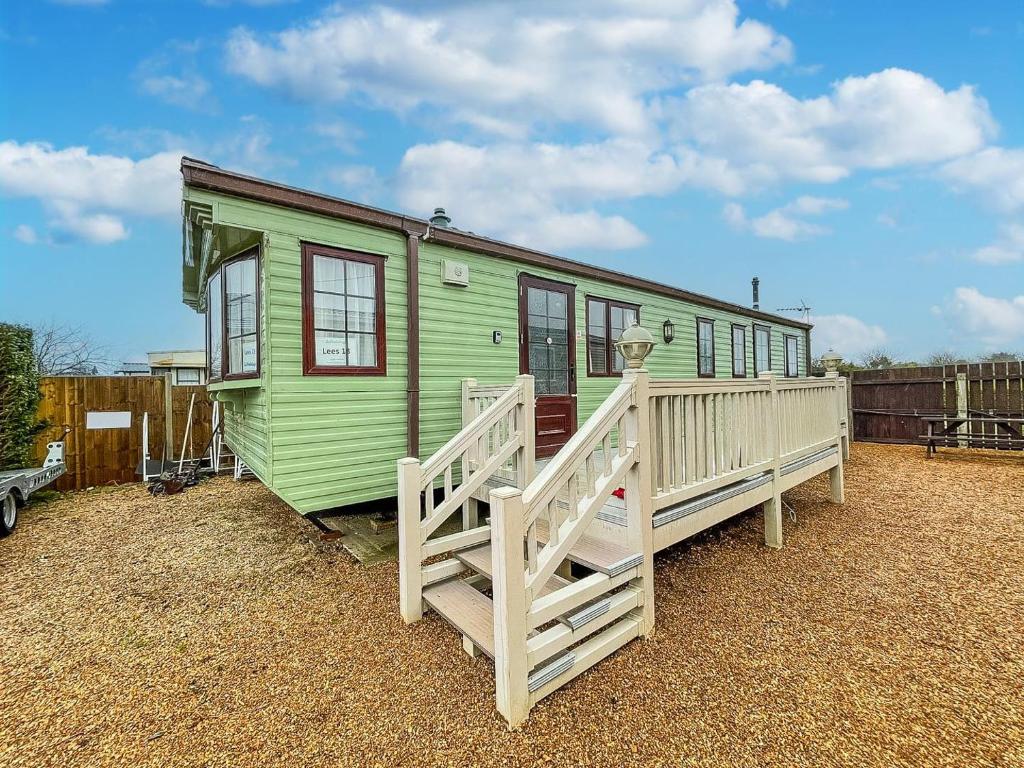 a green house with a porch and a fence at 6 Berth Dog Friendly Caravan In Hunstanton, Minutes From The Beach Ref 13013l in Hunstanton