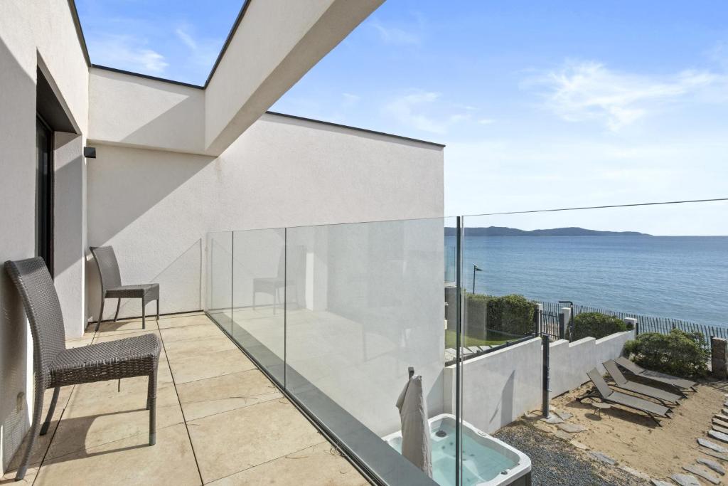 un balcon avec une chaise et une vue sur l'océan dans l'établissement Villa Azur, à Cavalaire-sur-Mer