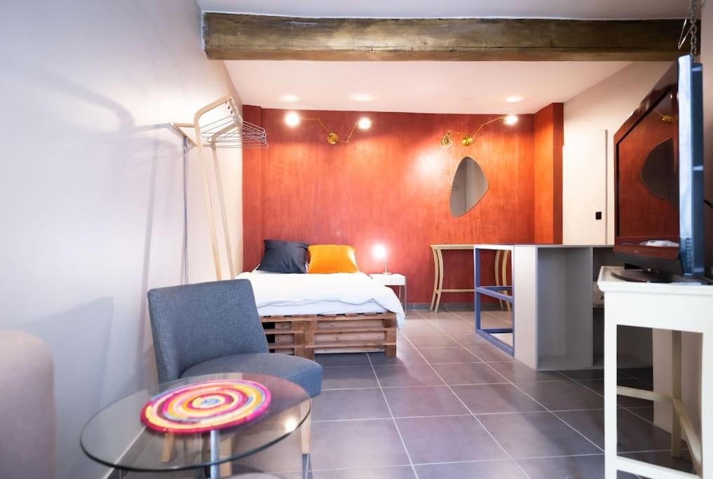 une chambre avec un lit, une table et une chaise dans l'établissement Le Coloré, Beau T2, Centre Historique, à Montpellier