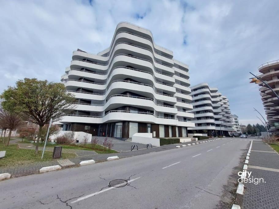 een groot wit gebouw aan de kant van een weg bij Waves Apartment 106 in Sarajevo