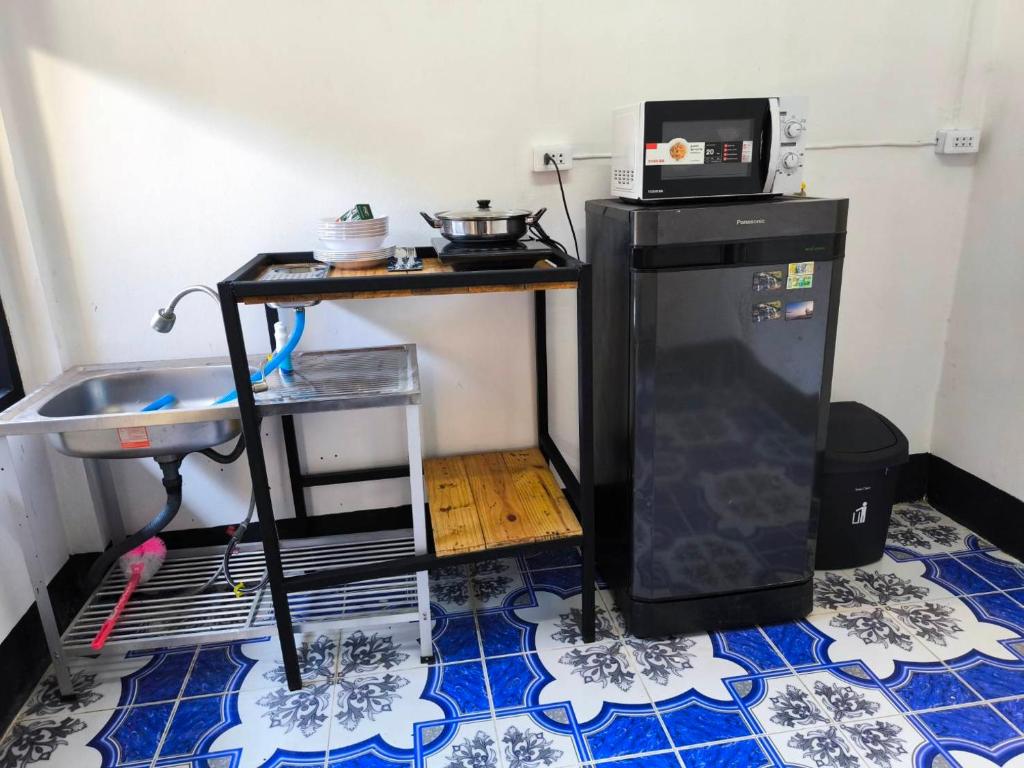 a small kitchen with a microwave and a refrigerator at บ้านพักเหมาหลังเชียงคาน ฮักเลย ฮักกัญ โฮมสเตย์ 2- ຊຽງຄານ ຮັກເລີຍ ຮັກກັນ ໂຮມສະເຕ2 -Chiang Khan Hugloei HugKan Homestay2 in Chiang Khan