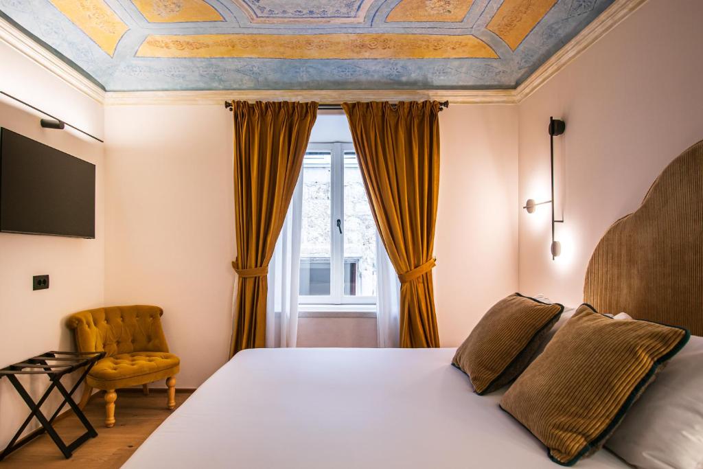 een slaapkamer met een bed en een stoel bij 7oaks Noble House in Dubrovnik