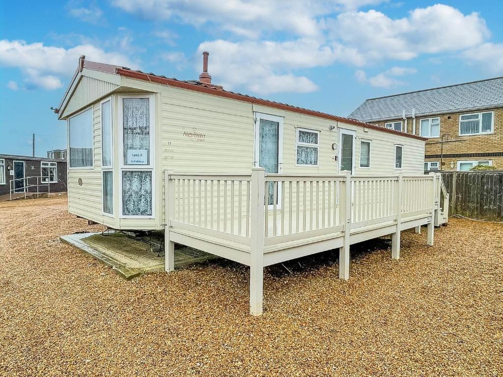 a white house with a porch and a fence at 6 Berth Caravan For Hire At Lees Caravan Park In Hunstanton Ref 13006l in Hunstanton
