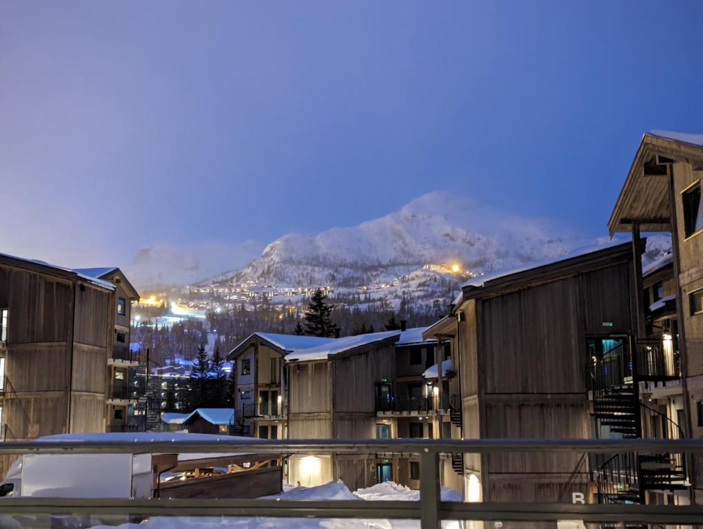 a group of buildings with a mountain in the background at Ski in/out Appartment Hemsedal in Kyrkjebøen