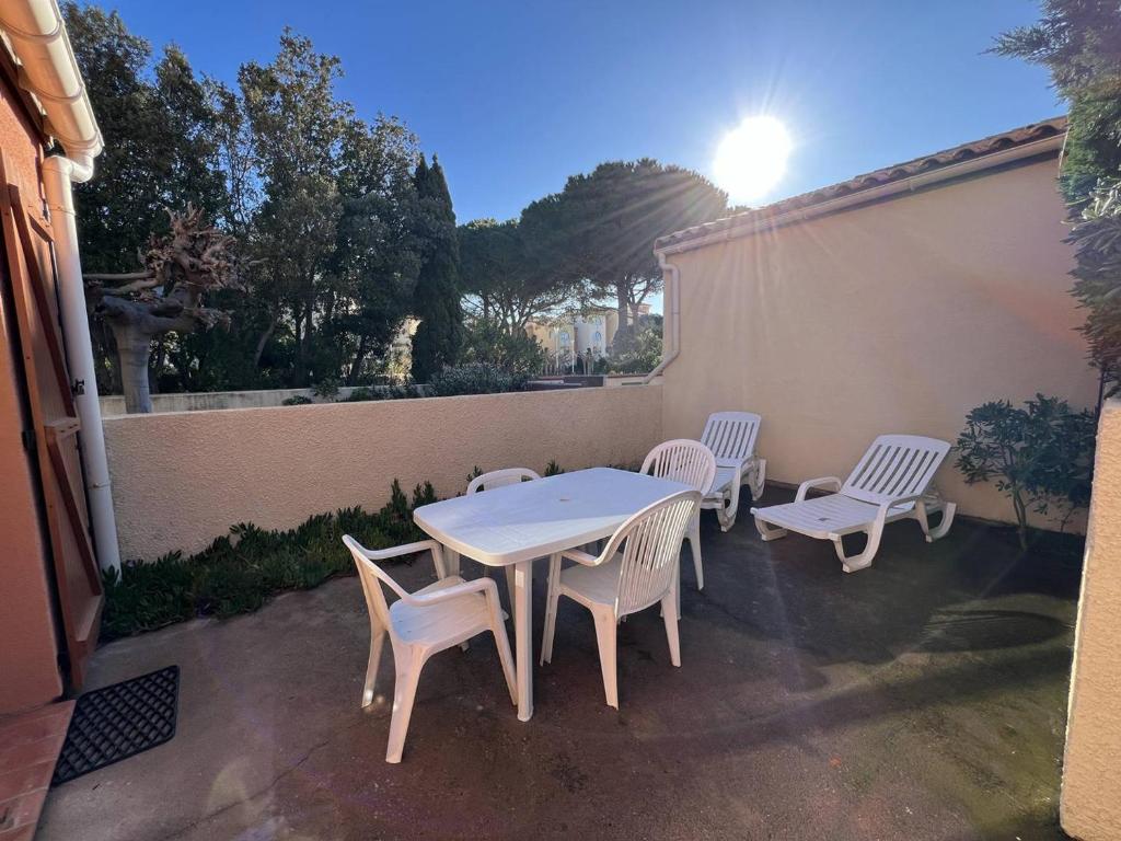 a white table and chairs on a patio at Villa T3 avec terrasse, 6 couchages, proche plage et commerces, quartier calme, parking privé - FR-1-81-365 in Port Leucate