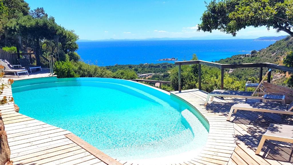a swimming pool with a view of the ocean at A ALTEZZA Palombaggia in Porto-Vecchio