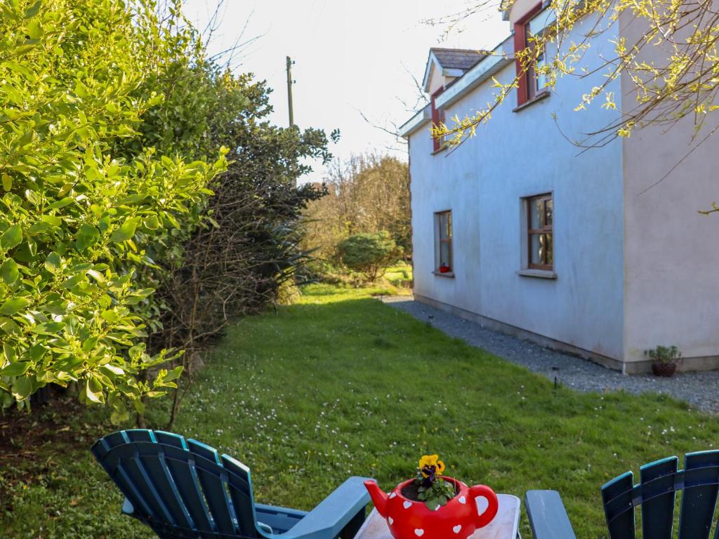 a table and chairs in a yard with a house at Wheatfield Lodge in Fethard on Sea
