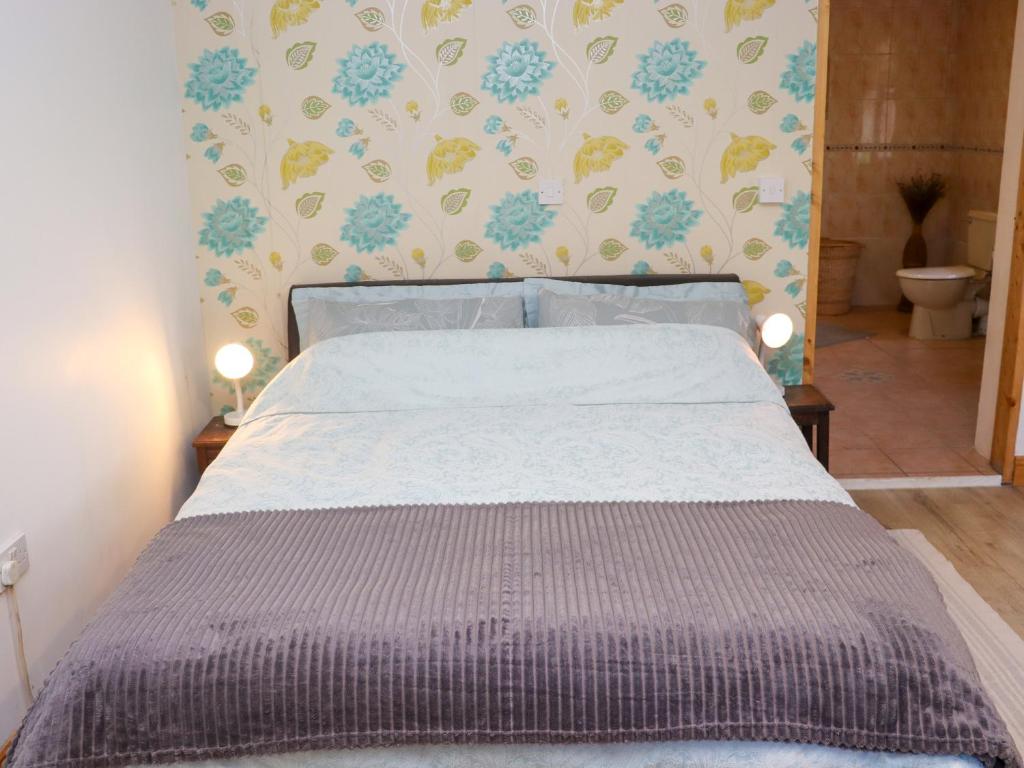 a bed in a small room with a bedspread at Wheatfield Lodge in Fethard on Sea