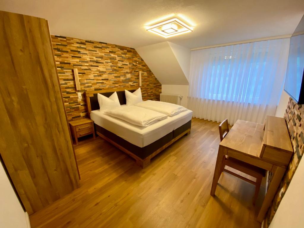 a bedroom with a bed and a brick wall at Hotel Restaurant Unikat in Zeltingen-Rachtig