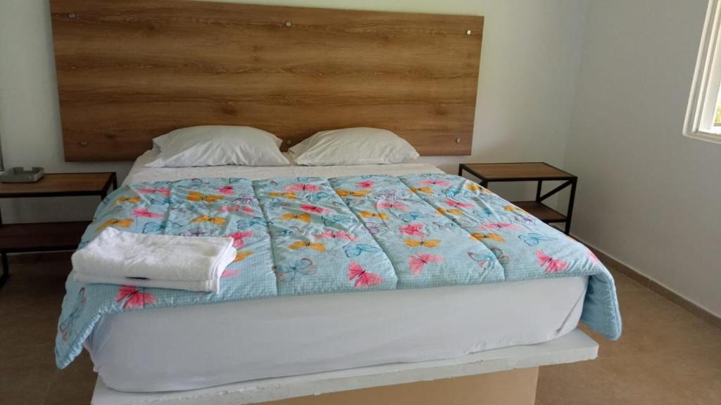 un letto con un piumone blu e due cuscini di FINCA HOTEL TIERRA NUEVA CAMPESTRE a La Vega