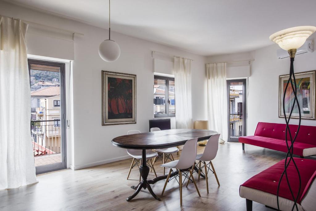 - un salon avec une table et un canapé rouge dans l'établissement Zafferana Apartment with Balcony by Wonderful Italy, à Zafferana Etnea