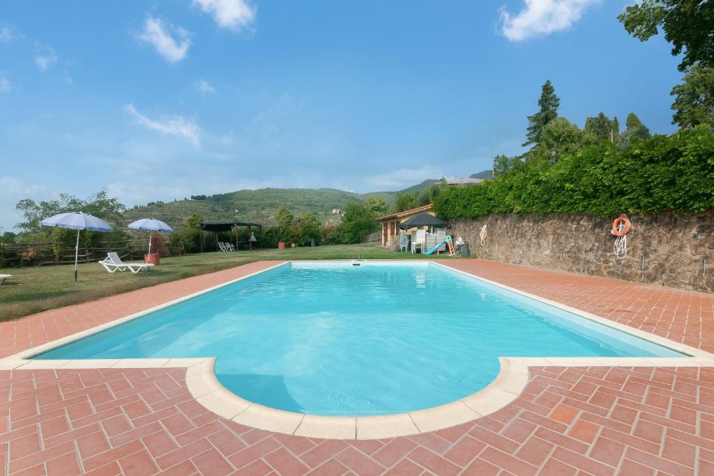 una piscina con suelo de ladrillo y pared de ladrillo en Appartamento La Chiocciola, en Pian di Scò