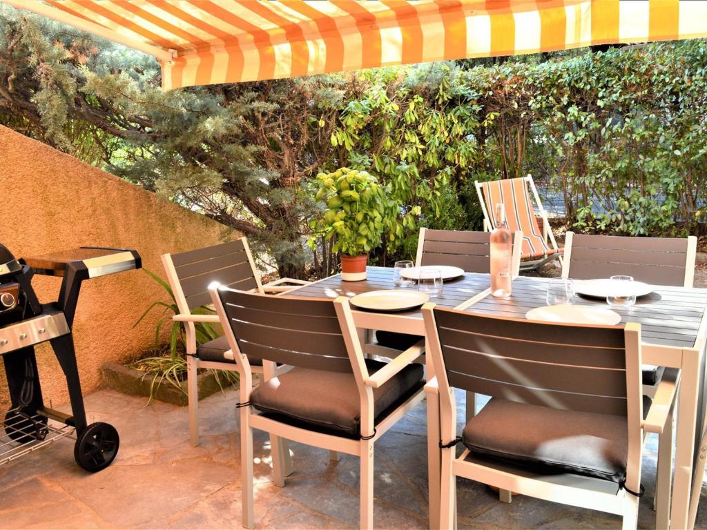 una mesa y sillas en un patio en Appartement Cavalaire-sur-Mer, 2 pièces, 4 personnes - FR-1-226B-56, en Cavalaire-sur-Mer