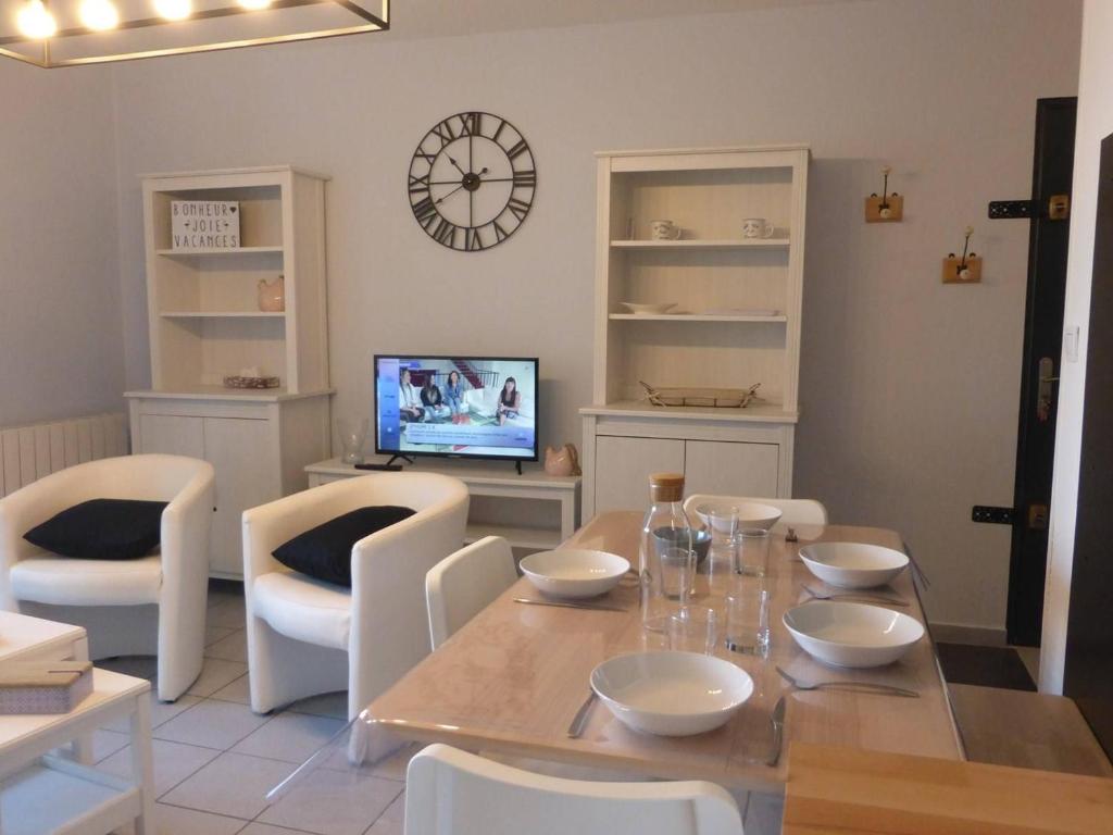 une salle à manger avec une table, des chaises et une horloge dans l'établissement Appartement Saint-Gilles-Croix-de-Vie, 3 pièces, 5 personnes - FR-1-224-769, à Saint-Gilles-Croix-de-Vie