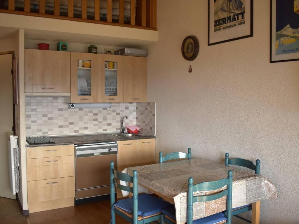 a kitchen with a table and chairs and a sink at Appartement Font-Romeu-Odeillo-Via, 2 pièces, 7 personnes - FR-1-580-27 in Font-Romeu-Odeillo-Via