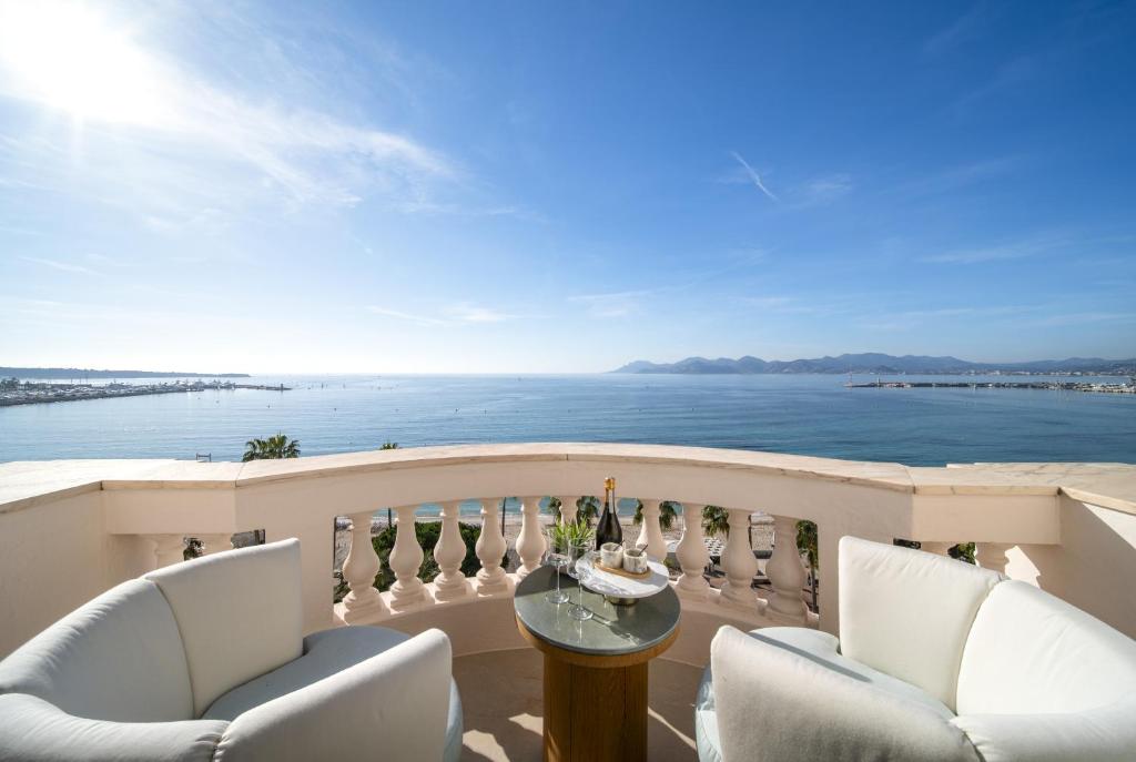un balcon avec des chaises et une table et l'océan dans l'établissement Le Palace Miramar, à Cannes