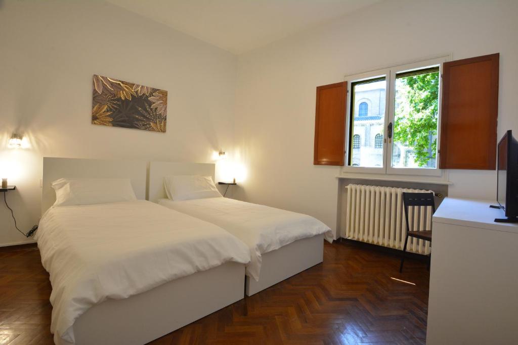 Casa Domus Galla Placidia - Superlative View - في رافينا: غرفة نوم بسريرين وتلفزيون فيها