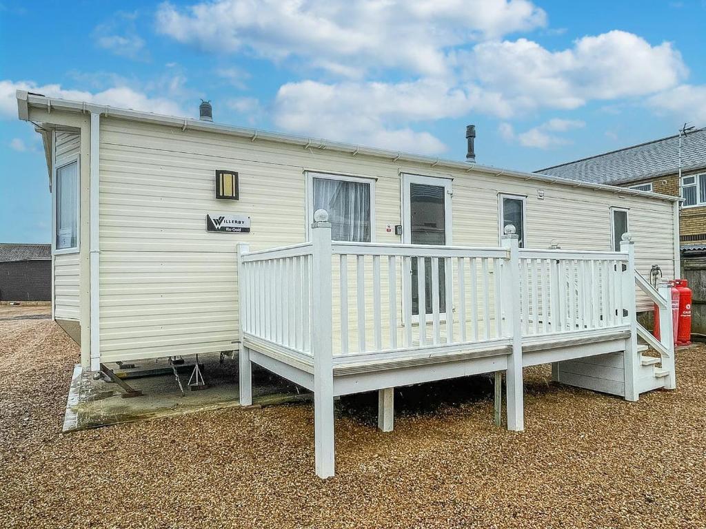 a white house with a porch and a balcony at Great Caravan For Hire By The Beach In Norfolk, By Hunstanton Beach Ref 13005l in Hunstanton