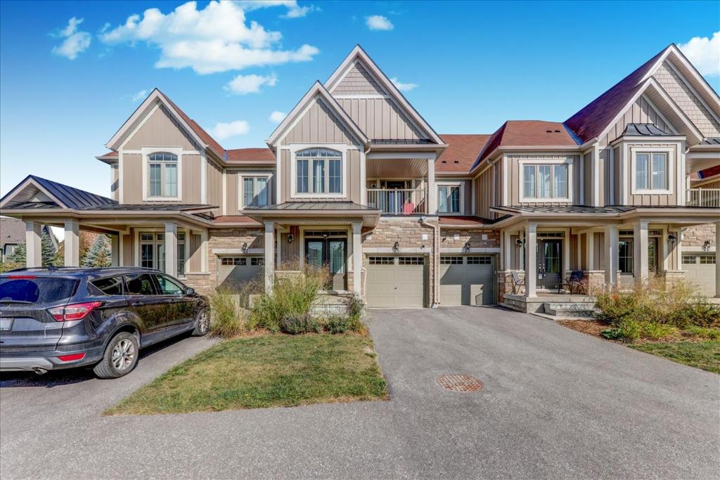a house with a car parked in front of it at Executive Town Home-Mountain View-Historic Snowbridge Village, Walking Distance to the Resort in Collingwood