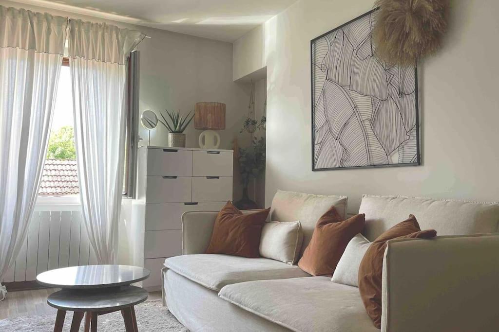 un salon avec un canapé et une table dans l'établissement Charmant petit 2p 10min Disney, à Guermantes