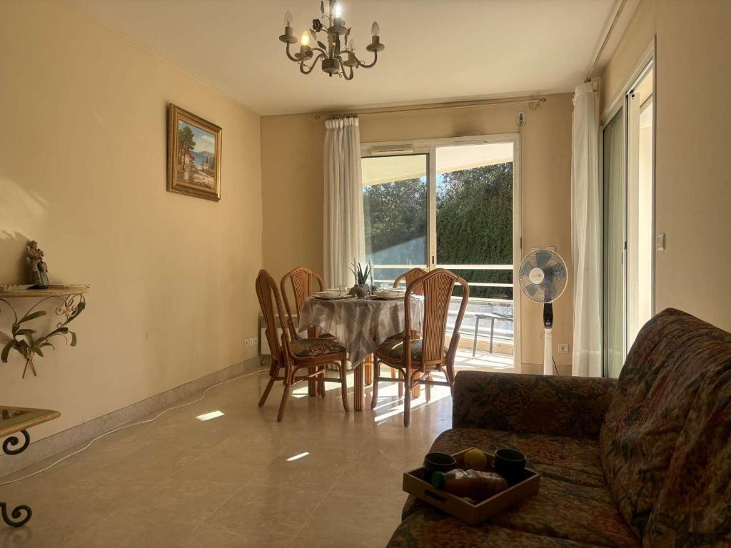 un salon avec une table, des chaises et un canapé dans l'établissement Appartement 2P à Juan les Pins : emplacement idéal, parking, terrasses, proche plage et commerces - FR-1-252-188, à Antibes