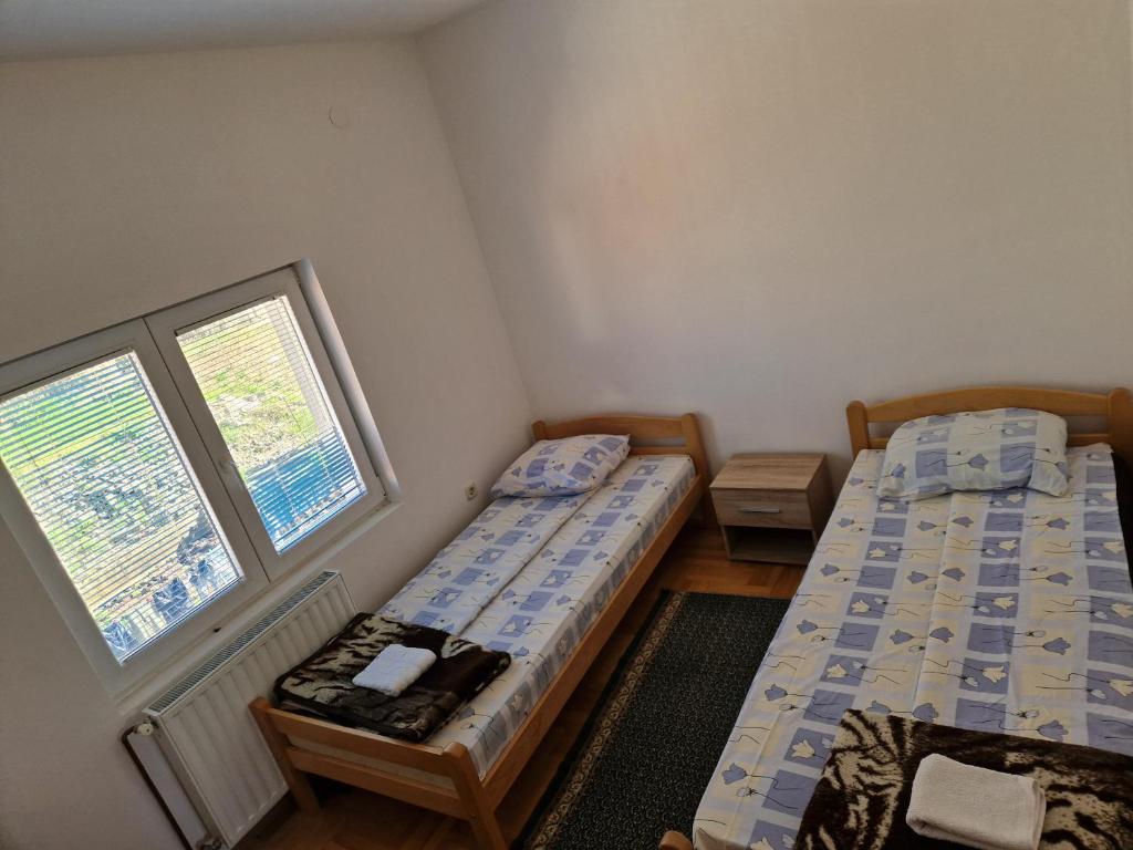 Zlatište的住宿－Apartman Vujovic，带2扇窗户的客房内的2张床