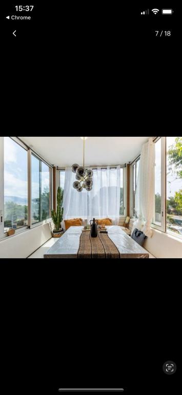 - une chambre avec une table dans une pièce dotée de fenêtres dans l'établissement Appartement Colline de Tarmaris, à La Seyne-sur-Mer