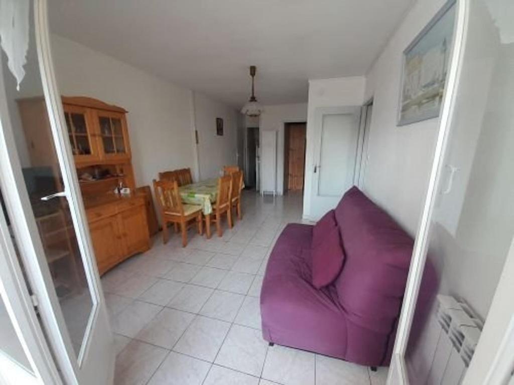 een woonkamer met een paarse bank en een tafel bij Appartement Saint-Hilaire-de-Riez, 3 pièces, 4 personnes - FR-1-324A-49 in Saint-Hilaire-de-Riez