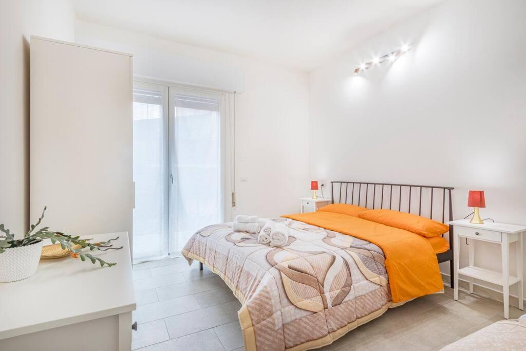 ein weißes Schlafzimmer mit einem Bett und einem weißen Tisch in der Unterkunft Mutina Design Suite - City life & Hesperia Hospital in Modena