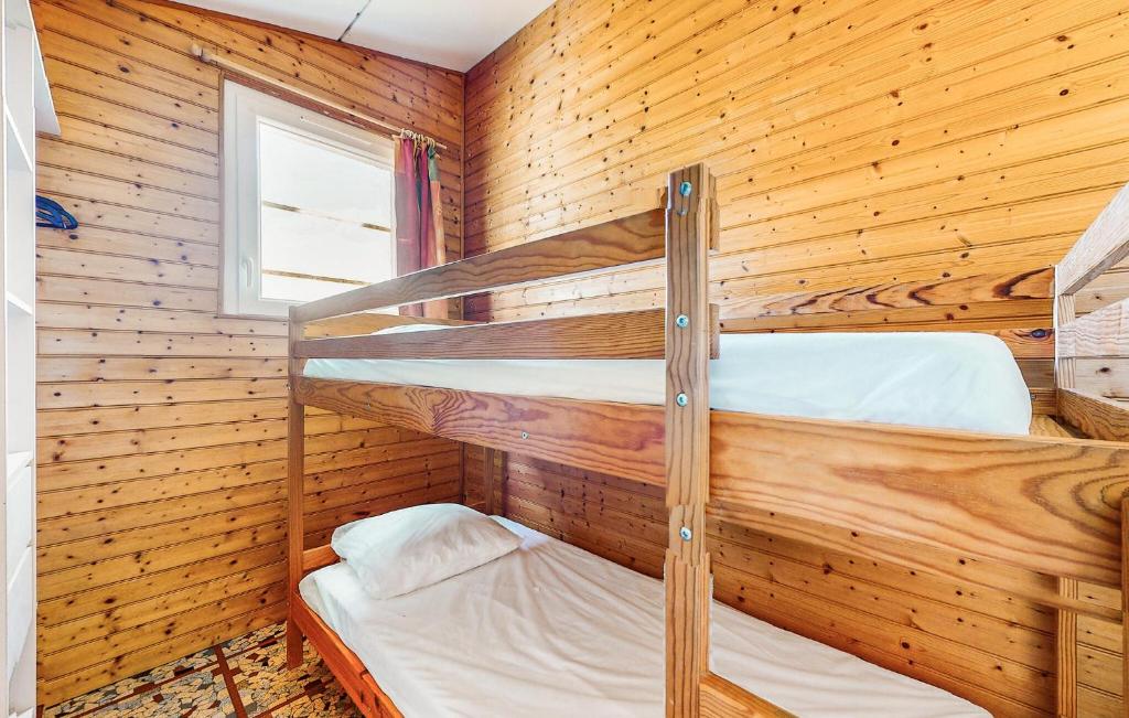 two bunk beds in a wooden room with a window at Lovely Home In Saint-savinien With Outdoor Swimming Pool in Saint-Savinien
