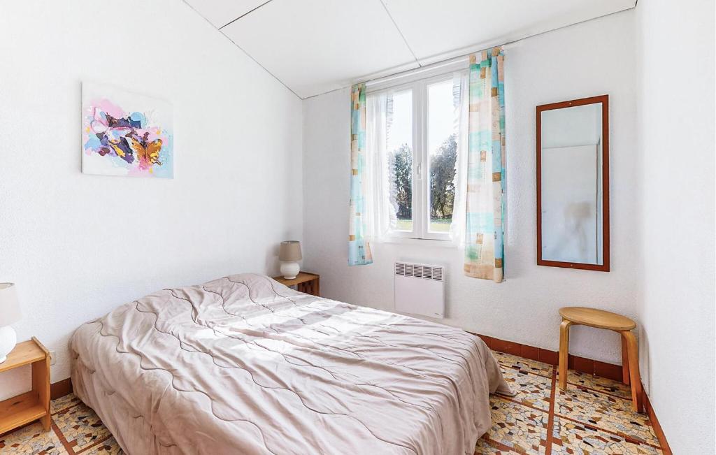 a white bedroom with a bed and a mirror at Lovely Home In Saint-savinien With Outdoor Swimming Pool in Saint-Savinien