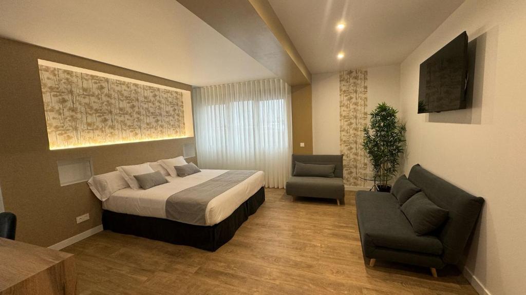um quarto de hotel com uma cama e duas cadeiras em Rey Don Sancho em Zamora