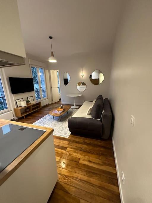 a living room with a couch and a television at Cosy Apt 4P-porte maillot -palais des congrés in Paris