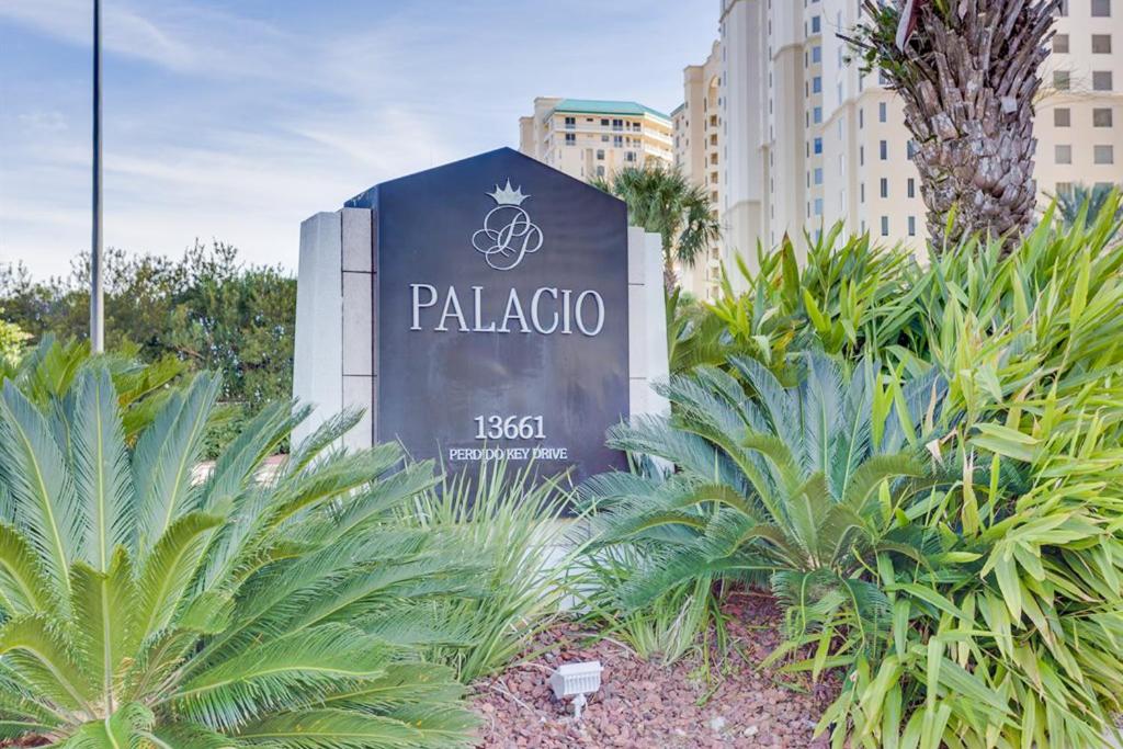 un panneau indiquant un hôtel avec des palmiers et des bâtiments dans l'établissement Palacio Condominiums II, à Perdido Key