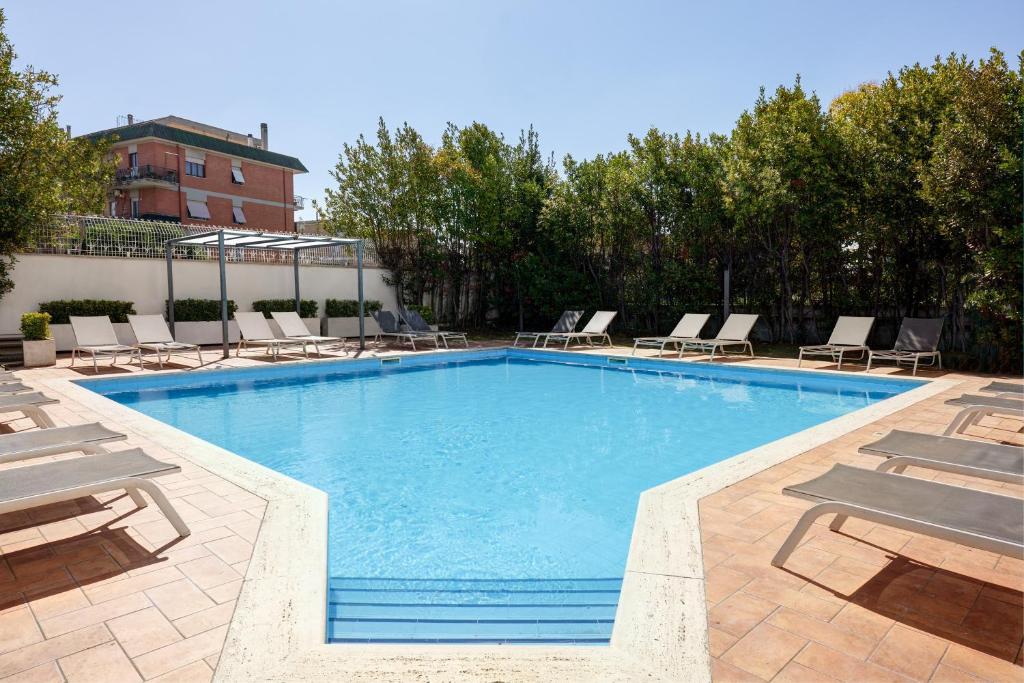 una gran piscina con tumbonas en Hotel Roma Tor Vergata, en Tor Vergata