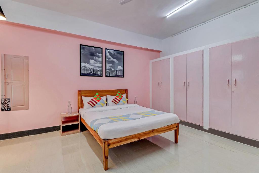 een slaapkamer met een bed en roze muren bij Capital O Elite Stay Jp Nagar Near SRI SATHYA GANAPATHI SHIRDI SAIBABA Temple in Bangalore