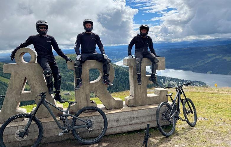 tres personas sentadas en la cima de un monumento con sus bicicletas en Enjoy MTB downhill and XC, hiking and SPA in Åre 29th July to 5th Aug at Holiday Club en Åre