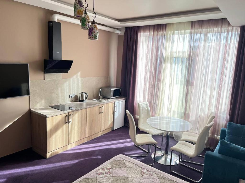 uma cozinha com mesa e cadeiras num quarto em Horizon Hotel em Odessa