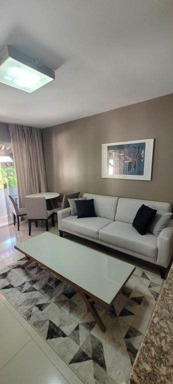 a living room with a white couch and a table at Casa 109 COND BRISAS DO FAROL n 07 in Salvador