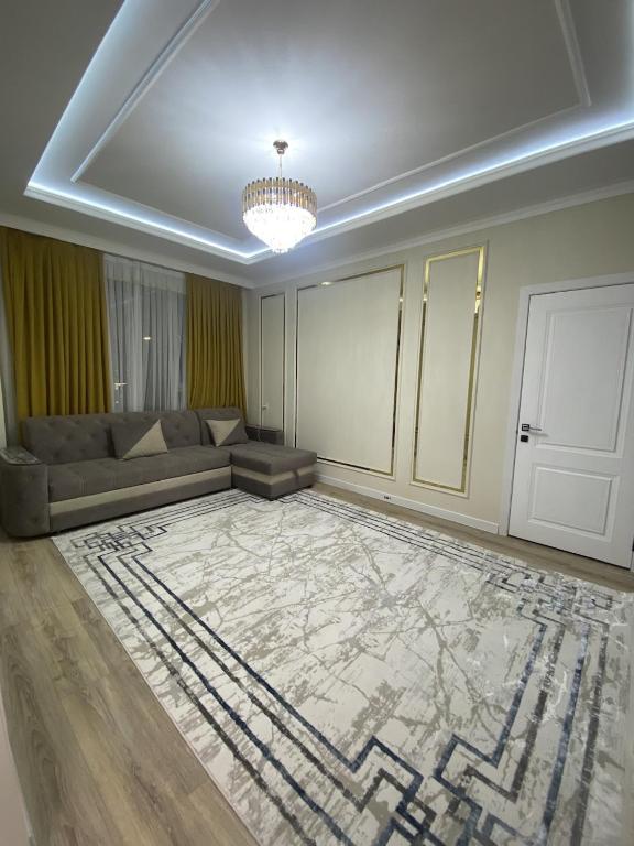 a living room with a couch and a large rug at Апартамент Рахима Плаза2 in Shymkent