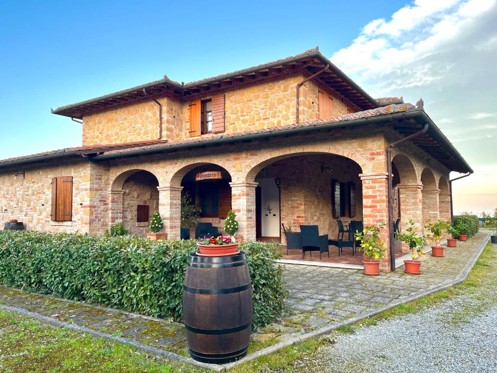 una gran casa de ladrillo con un barril delante de ella en Agriturismo Il Gonzeto, Montepulciano, en Montepulciano