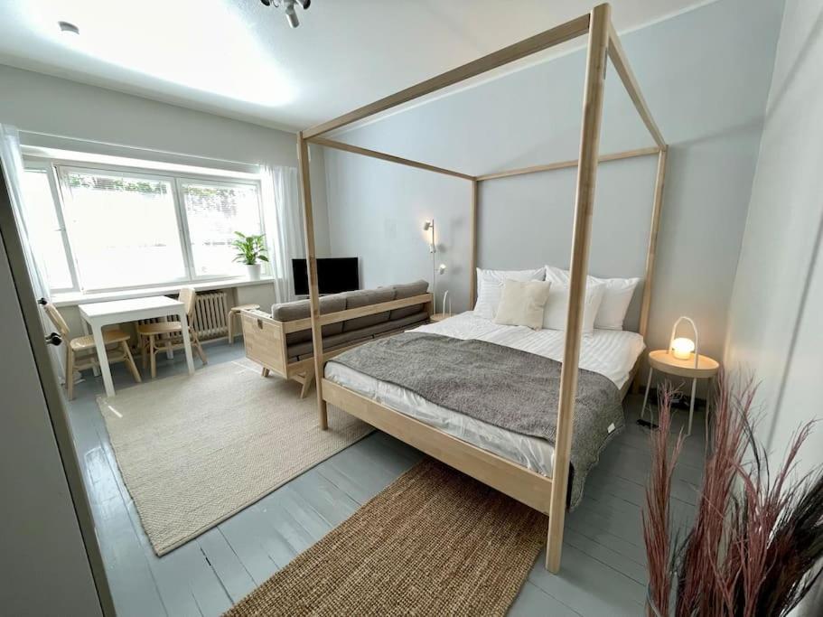 a bedroom with a canopy bed and a desk at Hogland Apartments - 1 in Kotka