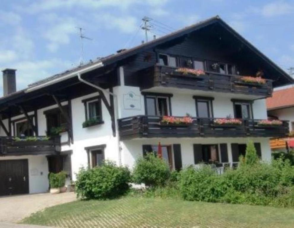 Una casa blanca con balcones y flores. en FeWo LEO im AKTIV Landhaus en Missen-Wilhams