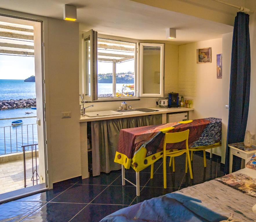 a kitchen with a sink and a table with chairs at La terrazza di Maria in Procida