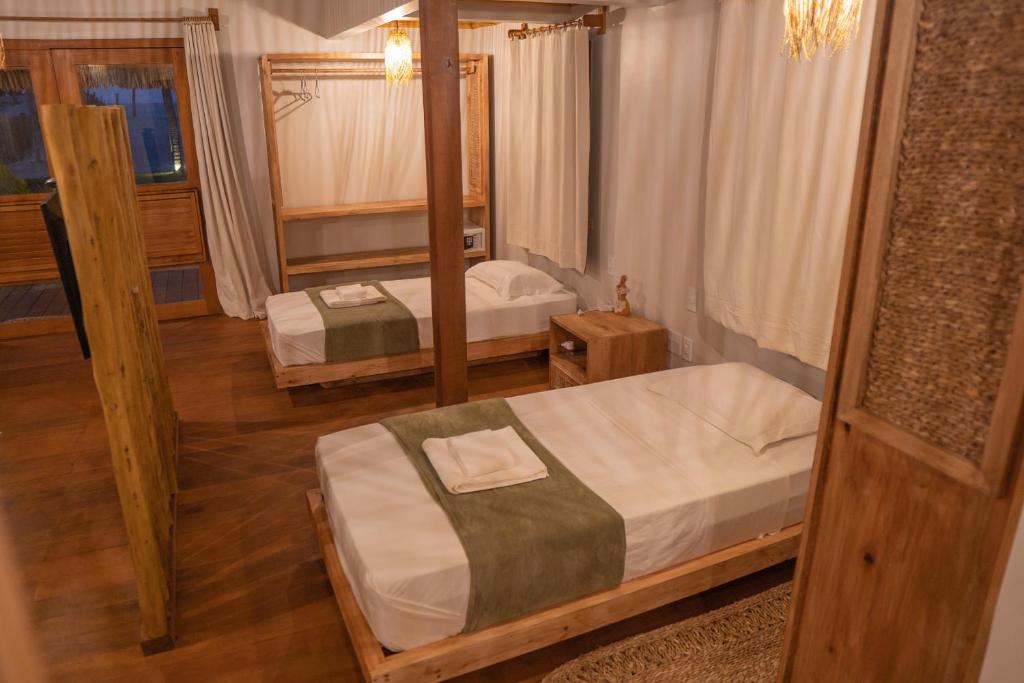 a bedroom with two beds and a mirror at Rancharia Charme Beach in Atins